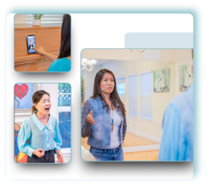 Joann C Chang teaching singing a girl in front of an audience.